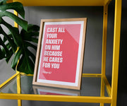 Framed poster with pink background and white text: 'Cast all your anxiety on Him because He cares for you' 1 Peter 5:7.