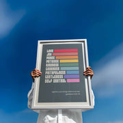Colorful poster featuring the Fruits of the Spirit with text from Galatians 5:22-23, held by a person outdoors.