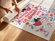 Hands rolling out a colorful poster featuring the text 'Good news of great joy' with floral designs and a scripture