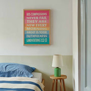 Colorful poster with text about faithfulness and compassion, displayed on a wall above a bed with blue bedding.