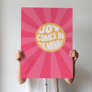 Poster featuring the text 'JOY COMES IN THE MORNING' in bold letters on a pink sunburst background, with Psalm 30:5 at the