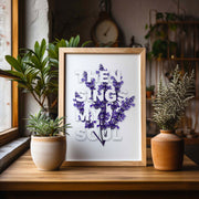 Framed poster with the text 'THEN SINGS MY SOUL' in 3D, surrounded by purple flowers, displayed on a wooden table.
