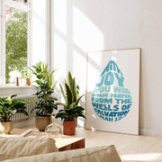 Poster featuring the text from Isaiah 12:3 in teal, displayed in a bright room with plants and natural light.