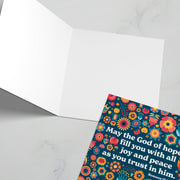 Greeting card with colorful floral design and text: May the God of hope fill you with joy and peace. Romans 15:13.