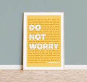 Yellow poster featuring the text 'Do Not Worry' and a bible verse from Matthew 6:25-34, framed and displayed on a wooden