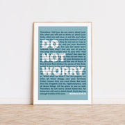 Blue poster featuring Matthew 6:25-34 text, framed in a light wood frame, minimalist design for wall art.