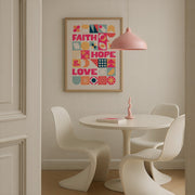 Poster featuring the words 'Faith, Hope and Love' in colorful typography, framed on a wall above a round table.