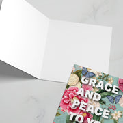 Greeting card featuring the text 'GRACE AND PEACE TO YOU' with floral and butterfly designs inside.