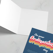 Ordination greeting card featuring colorful text on a dark background, blank inside.