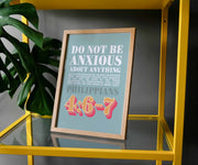 Framed poster with the text 'Do Not Be Anxious About Anything' and Philippians 4:6-7, displayed on a yellow shelf.
