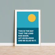 Poster featuring a blue and teal design with a yellow sun and the text: This is the day that the Lord has made. Let us