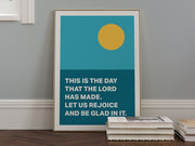 Framed poster with a yellow sun and teal background featuring the text: This is the day that the Lord has made.