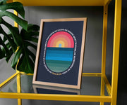 Framed poster featuring a colorful sunset over water with the text of Psalm 23 in a circular design, displayed on a yellow