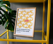 Framed poster featuring yellow background with white fish and one red fish, displaying Romans 12:2 text.