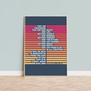 Poster with colorful horizontal stripes featuring Romans 8:38-39 text on a dark background, framed and displayed on a wall.