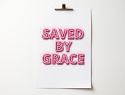 Neon effect poster with the text 'SAVED BY GRACE' in pink letters, clipped to a white background