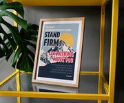 Framed poster with mountains and sun, featuring the text 'Stand Firm Let Nothing Move You' in bold colors.