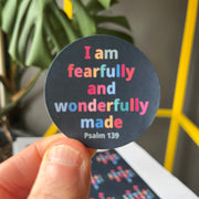 Round sticker with colorful text: 'I am fearfully and wonderfully made. Psalm 139' on a dark background.
