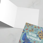 Open sympathy card featuring floral design and the word 'sympathy' in blue on a green background.