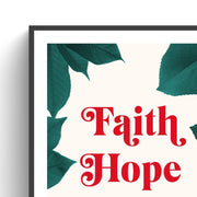 Poster featuring the words 'Faith Hope Love' in bold red letters, surrounded by green leaves on a cream background.