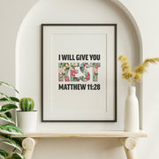 Framed poster with floral letters spelling 'REST' and the text 'I WILL GIVE YOU' and 'MATTHEW 11:28' below.